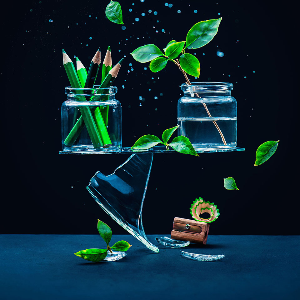 2AM1HN2 - Glass jars with pencils and plants balancing on a shard, art vs nature concept 