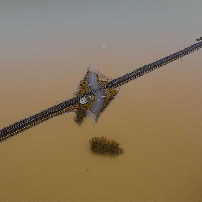 Flooded road passing through the railway. A road under water.