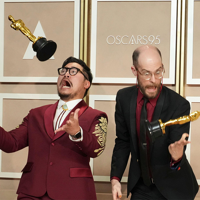 2PBPK1E - Daniel Kwan, left, and Daniel Scheinert toss their awards for best picture for "Everything Everywhere All at Once" as they pose in the press room at the Oscars.