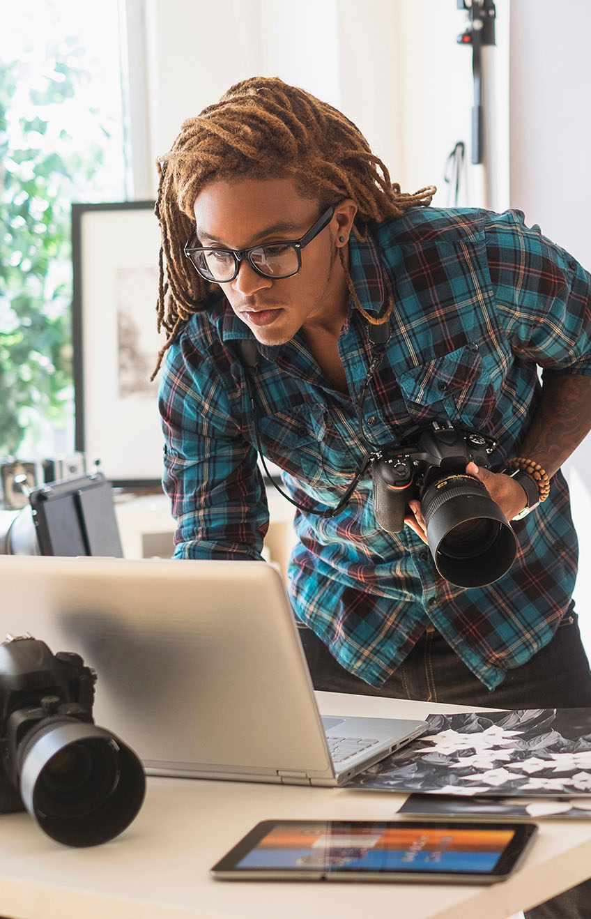 FF103H - Mixed race photographer using laptop in studio