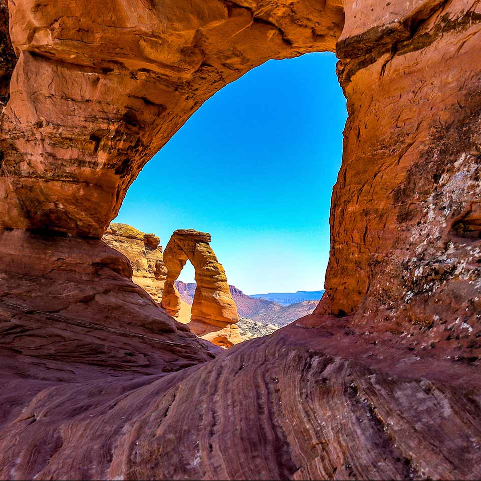 MR0FX7 - The Arches National Park, Moab Utah. A view from one of the smaller arches shows the Delicate Arch in the background. Resembles a Cat's Eye 